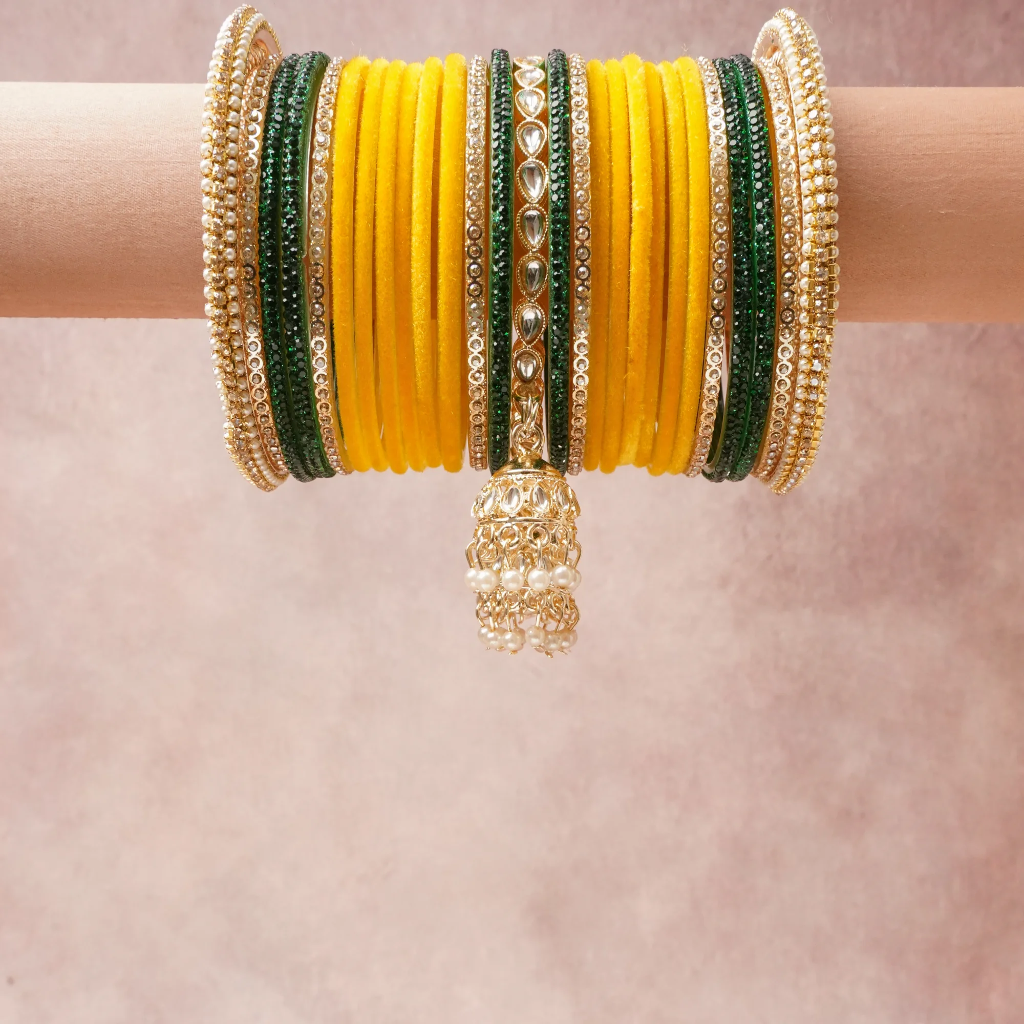 A commanding Canary Yellow anchors this beautiful set, enriched with accents of Emerald Green, Pearl White that add depth and dimension.

Featuring a striking composition of Velvet-wrapped Base Metal, Glass, Faux Kundan Stones, Faux Emerald Stones, Faux Pearls, Gold-plated Alloy, this set carries intricate craftsmanship and strong presence. Grand in form, it is created for moments that deserve to be marked.